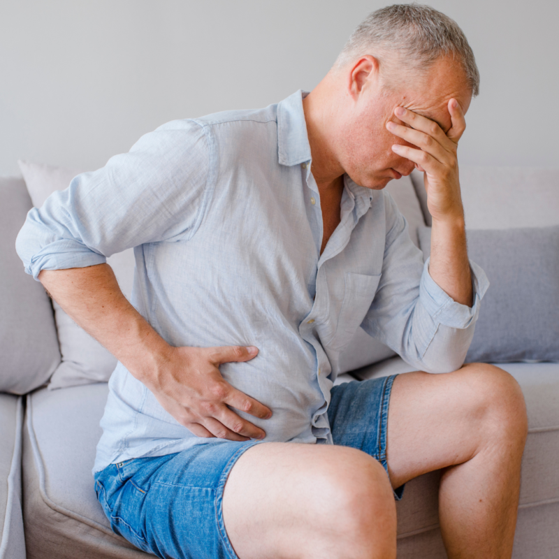 Man holding his stomach uncomfortably due to constipation from semaglutide